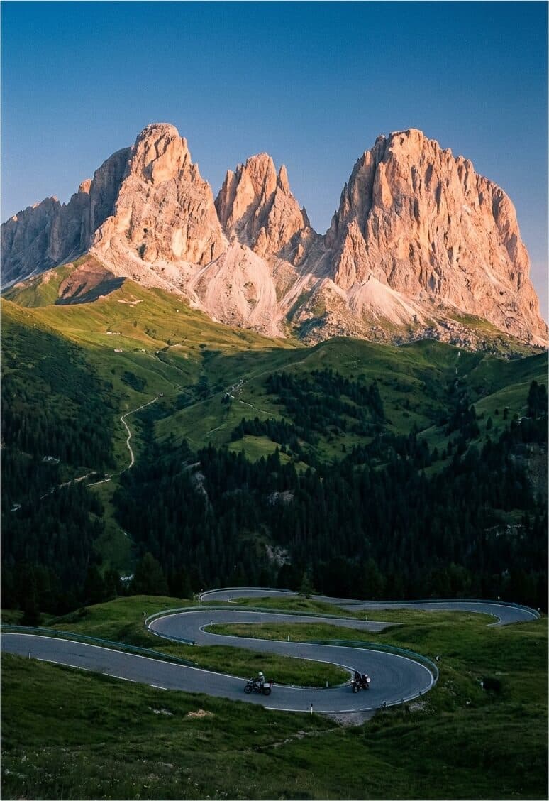 Serpentinen einer Dolomitenpassstrasse vor den leuchtenden Kalksteintürmen im Abendlicht